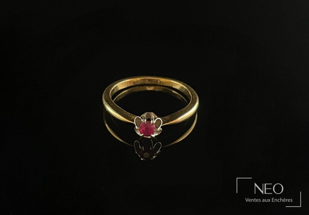 Bague en or jaune et platine avec pierre rouge montée en serti griffe