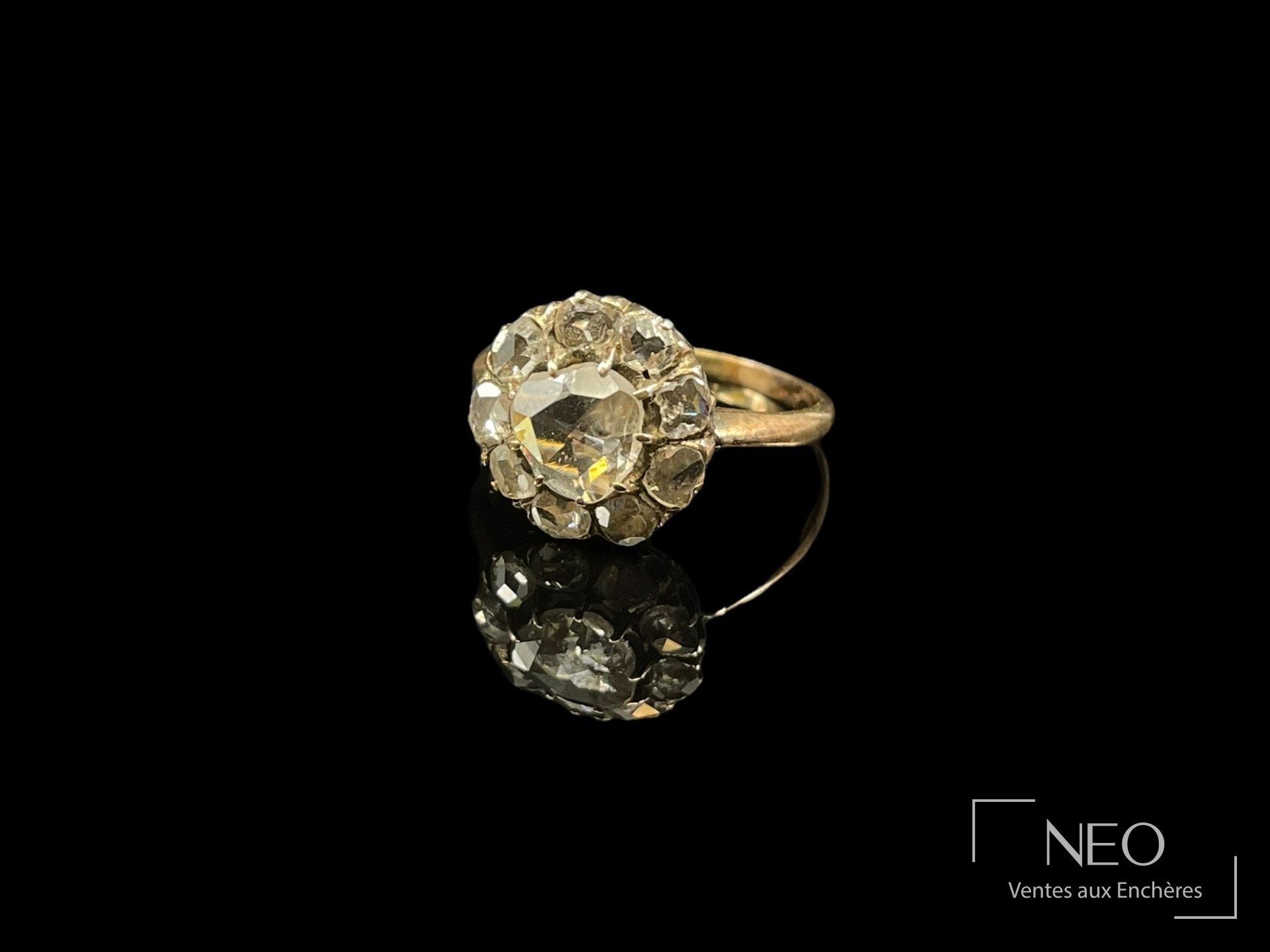 Bague en or rose ornée d'un diamant central entouré de diamants de taille rose