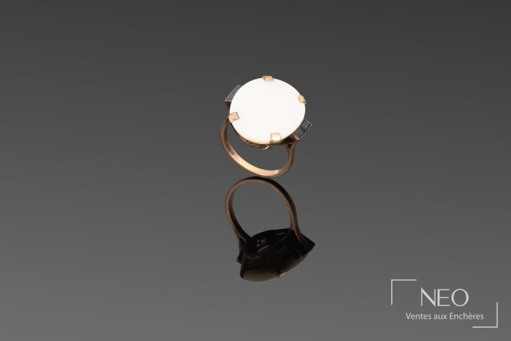 Bague en or rose avec pierre opalescente ovale retenue par des griffes