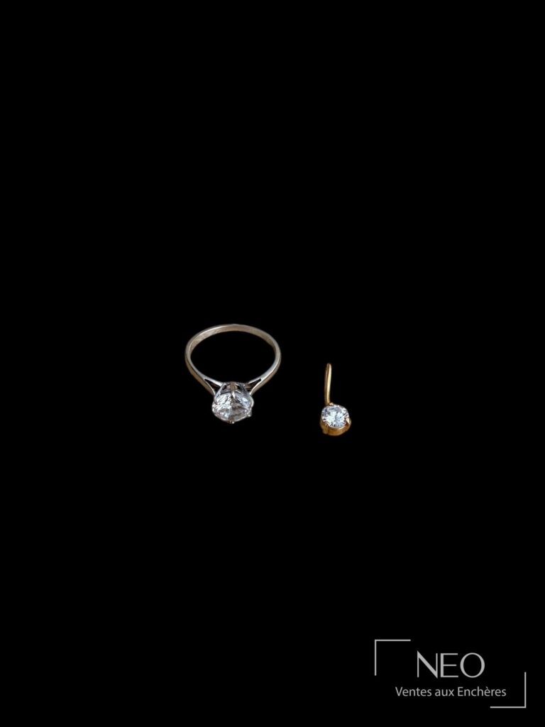 Bague en or gris et petit pendentif en or jaune avec pierre blanche sur fond noir