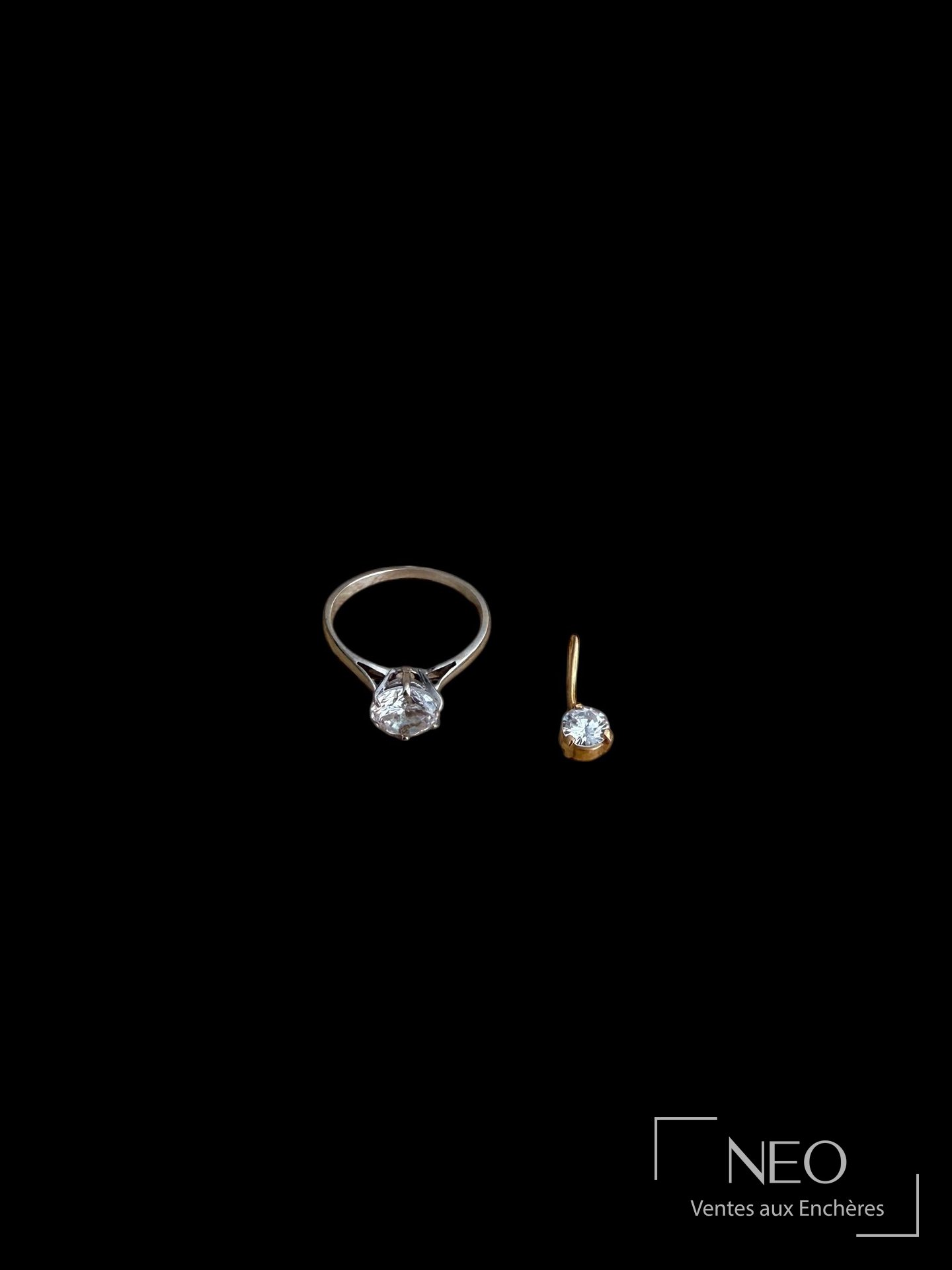 Bague en or gris et petit pendentif en or jaune avec pierre blanche sur fond noir