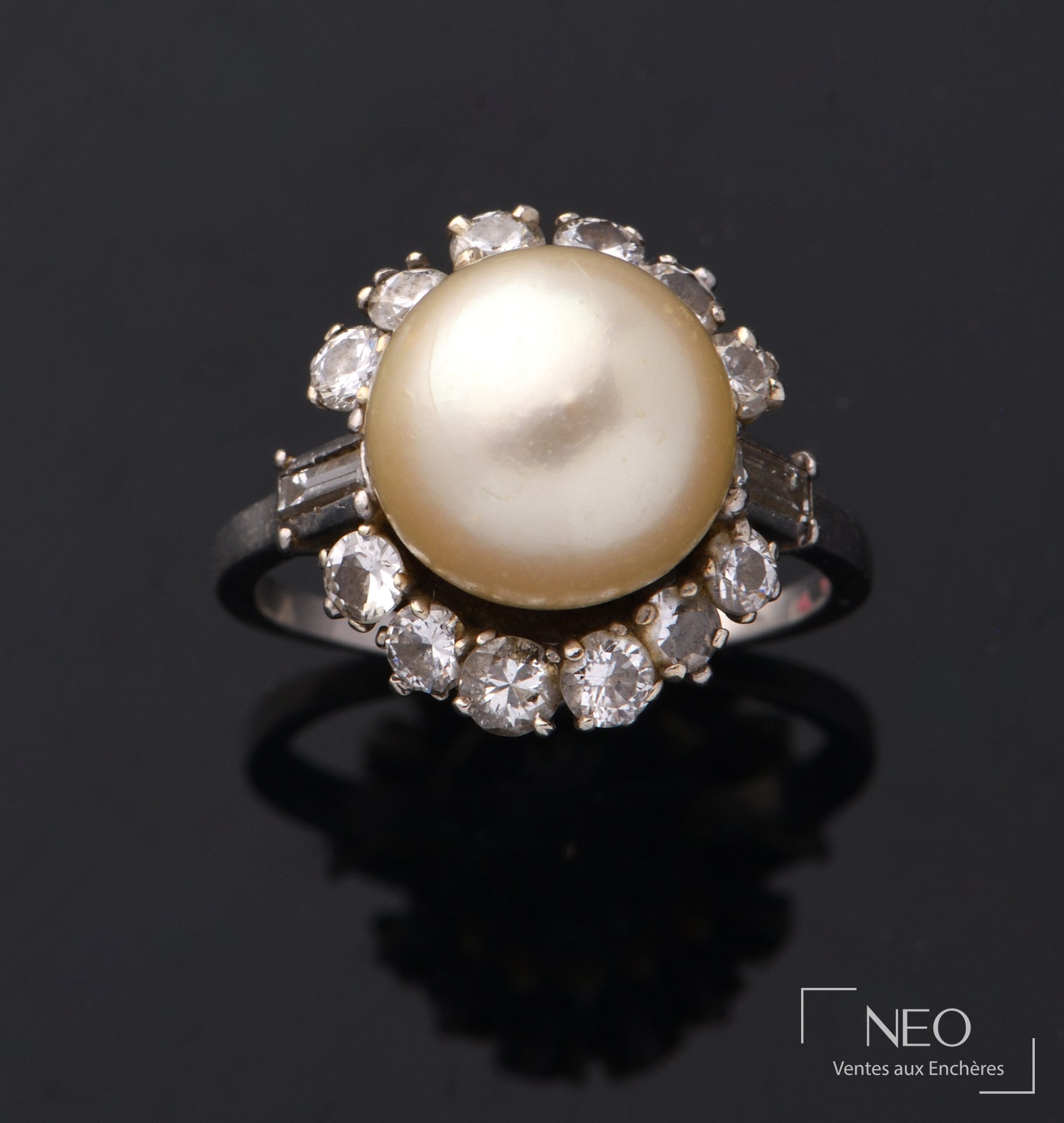 Bague en platine centrée d’une perle de culture blanche et diamants