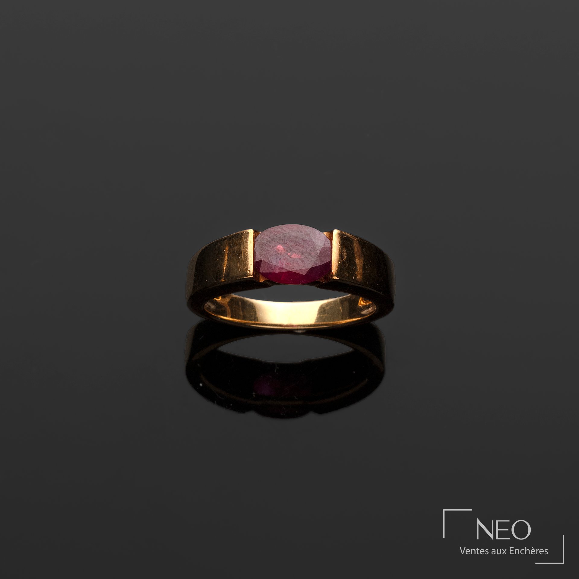 Bague ruban en or jaune 18 carats centrée d’un rubis taille émeraude
