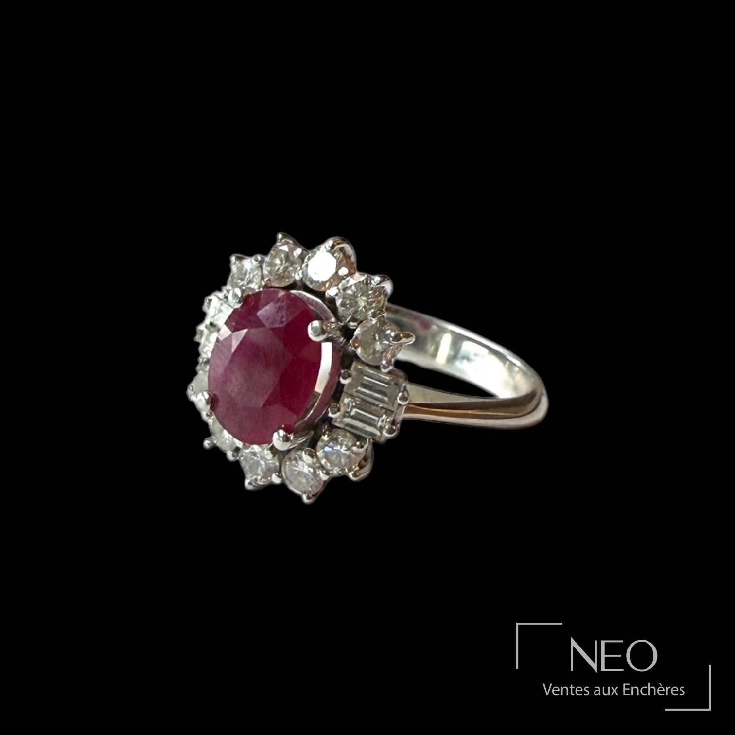 Bague en or blanc avec rubis ovale entouré de diamants sur fond noir