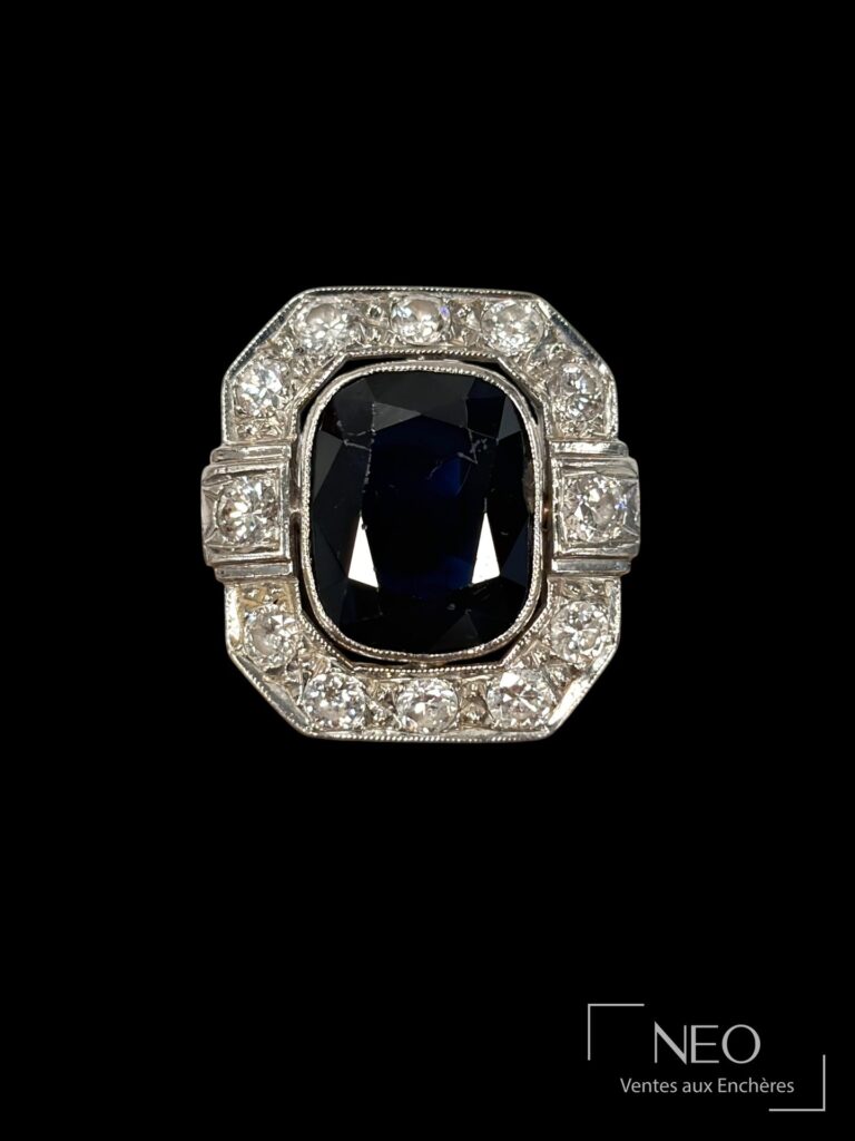 Bague en platine ornée d’un saphir coussin entouré de diamants