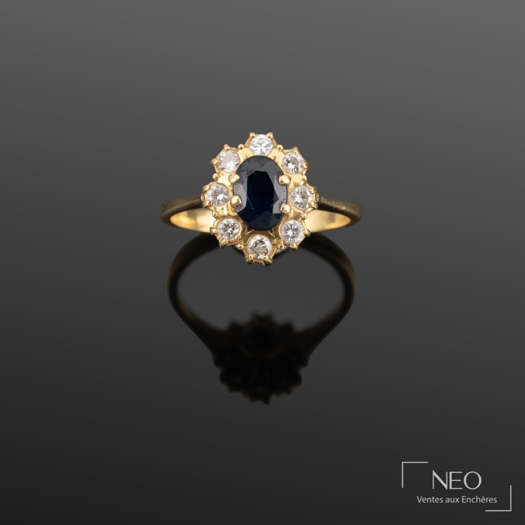 Bague en or jaune avec saphir ovale central entouré de brillants