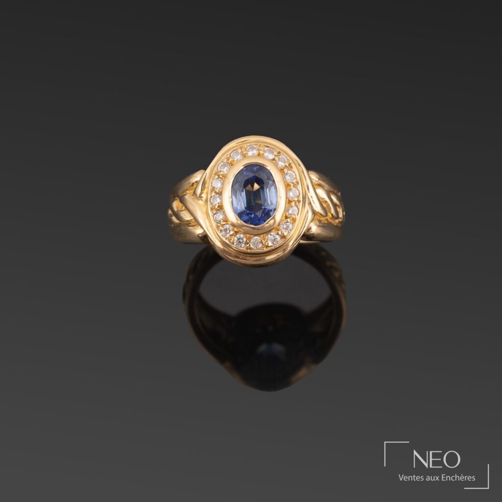 Bague en or jaune ornée d’un saphir ovale entouré de brillants