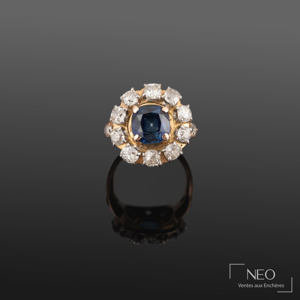 Bague en or jaune sertie d’un saphir bleu entouré de dix brillants