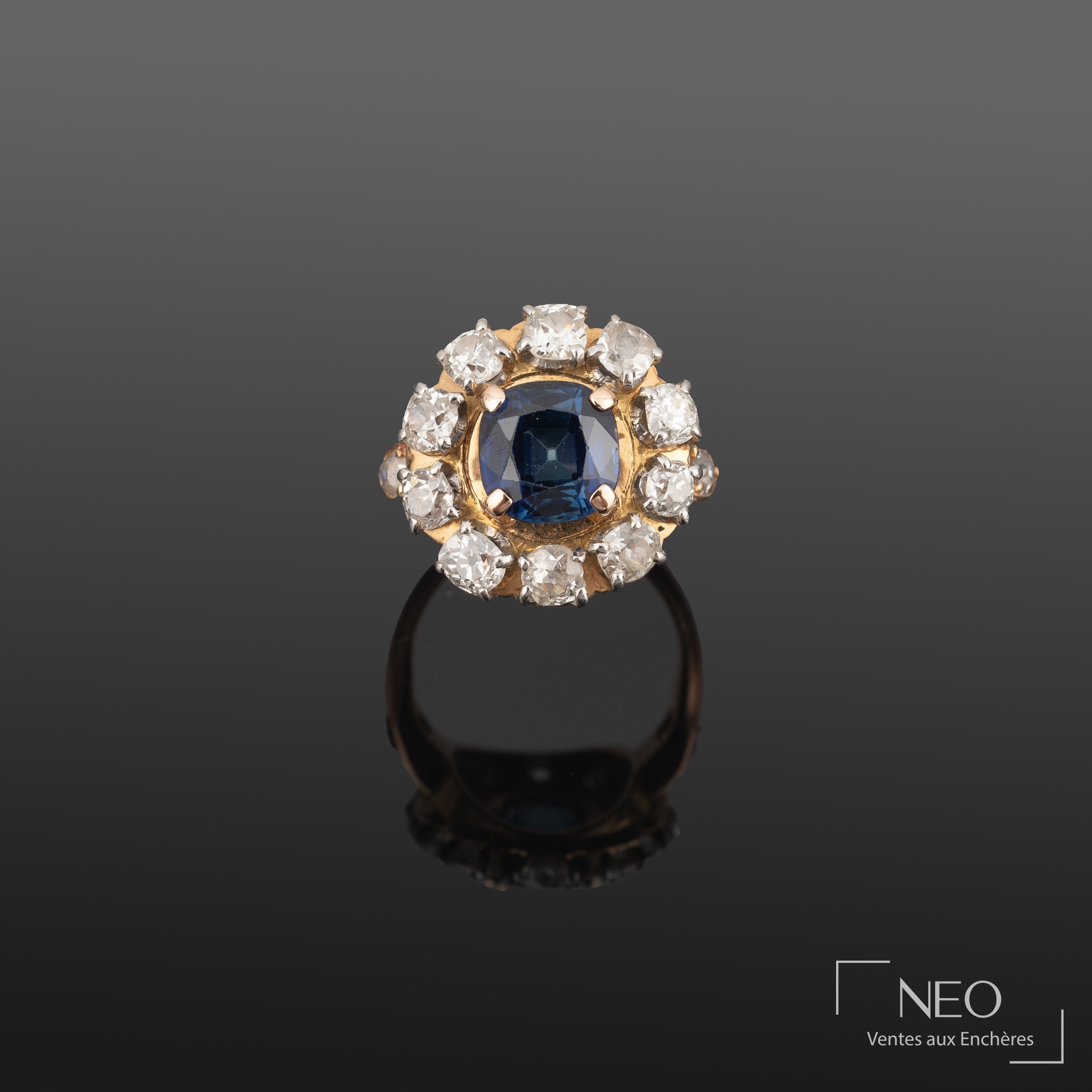 Bague en or jaune sertie d’un saphir bleu entouré de dix brillants