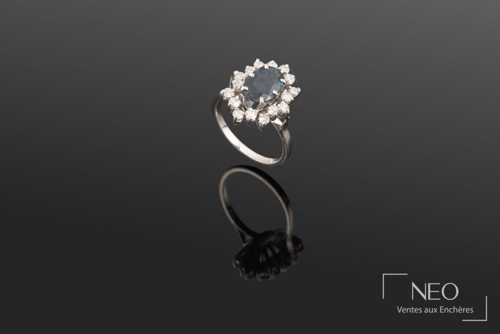 Bague en or gris avec saphir ovale et entourage de diamants