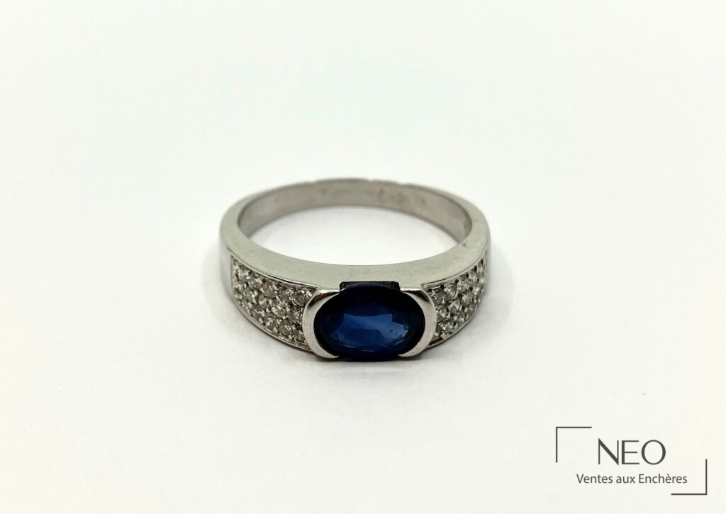 Bague en or gris avec saphir ovale bleu et pavage de brillants
