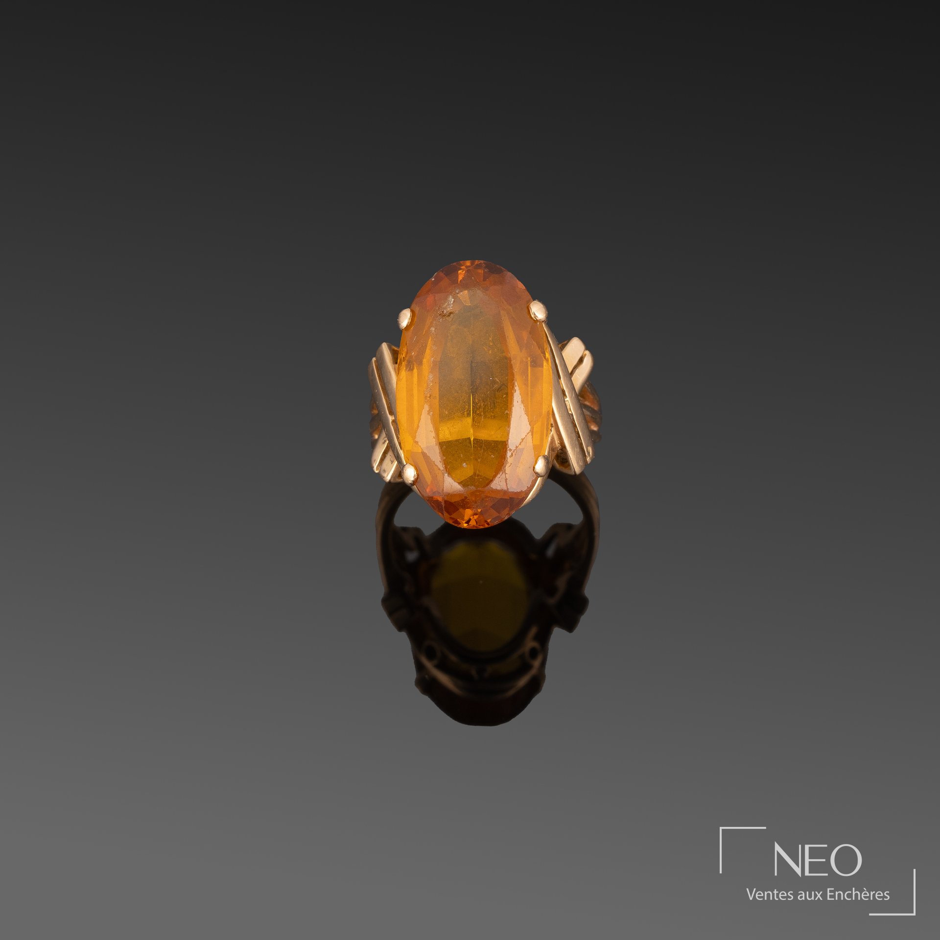 Bague en or jaune sertie d’un saphir synthétique orange ovale