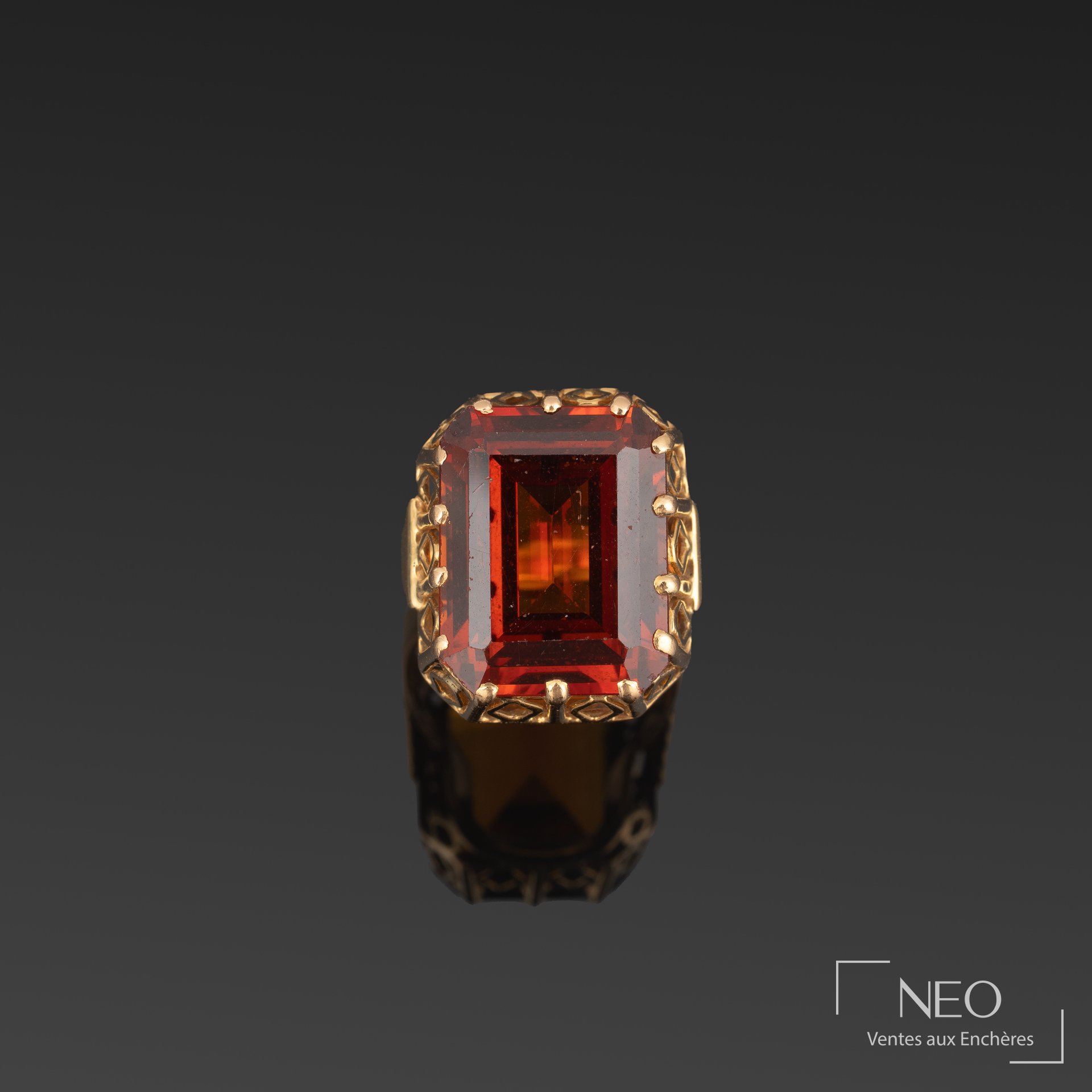 Bague en or jaune sertie d’une pierre orange rectangulaire vue de face
