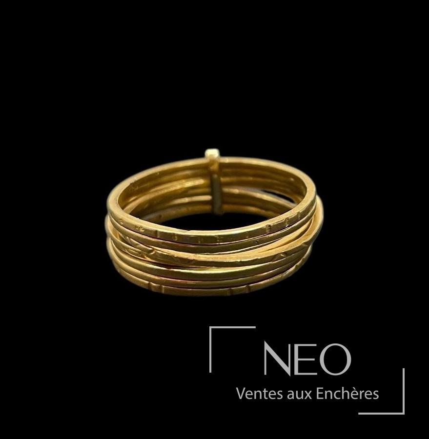 Bague semainier en or jaune à plusieurs anneaux sur fond noir