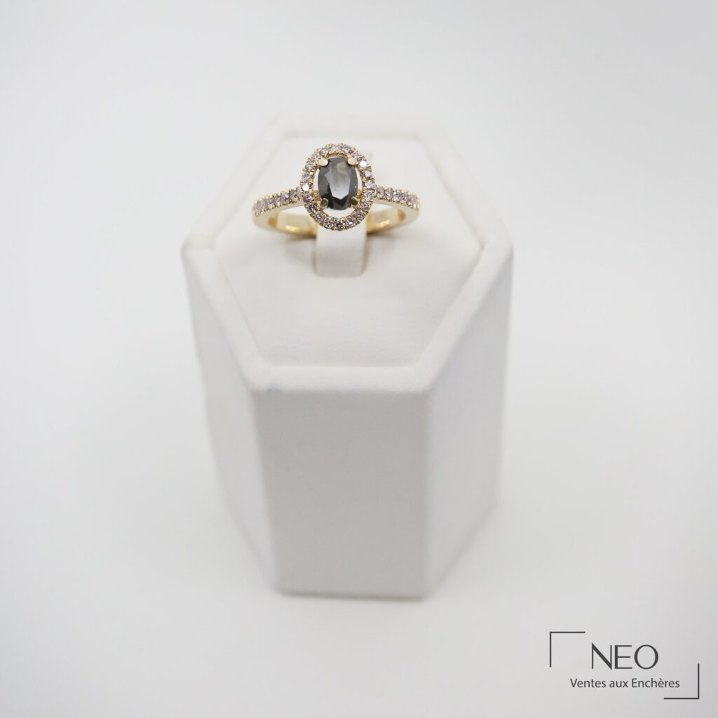 Bague solitaire en or jaune avec diamant ovale sombre entouré de diamants