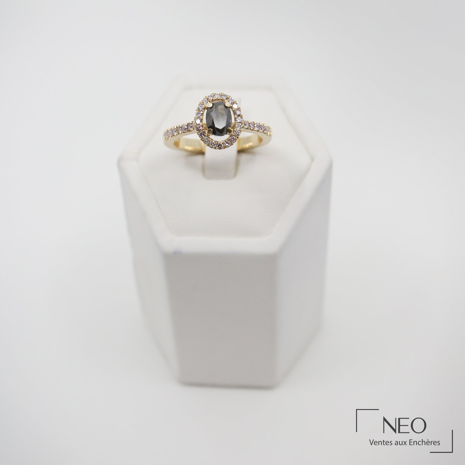 Bague solitaire en or jaune avec diamant ovale sombre entouré de diamants