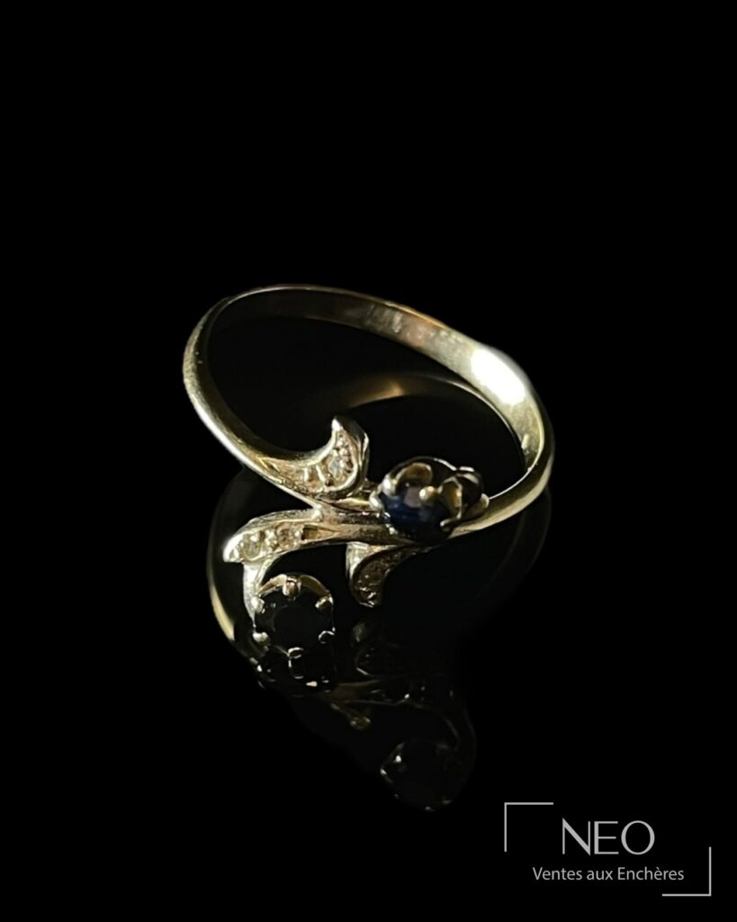 Bague toi et moi en or gris avec deux saphirs et des diamants sur fond noir