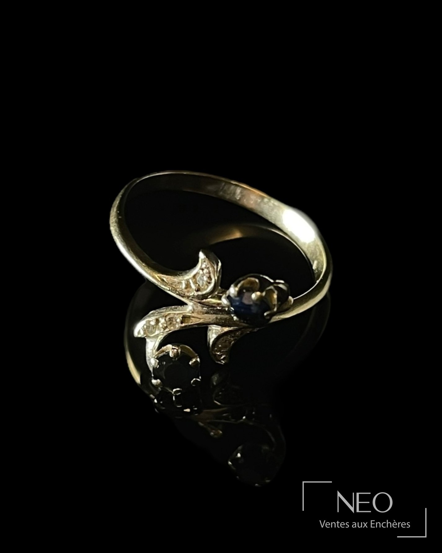Bague toi et moi en or gris avec deux saphirs et des diamants sur fond noir