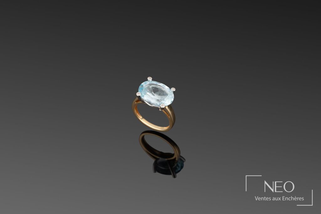 Bague en or jaune avec topaze bleue ovale sertie de quatre griffes