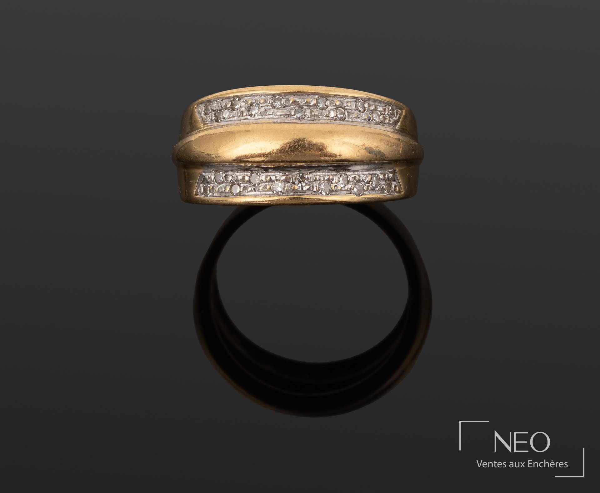 Bague triple jonc en or jaune et gris avec bande de diamants sur fond sombre