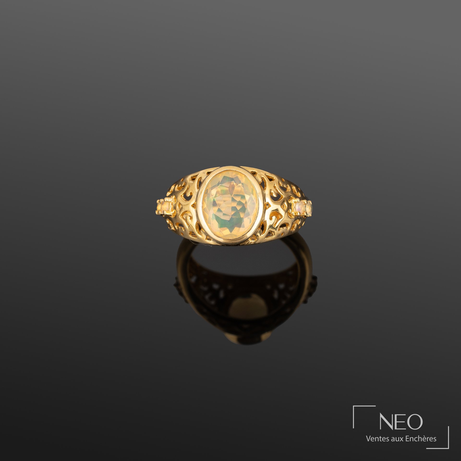 Bague en vermeil avec cabochon d’opale central et anneau ajouré rehaussé de petites opales