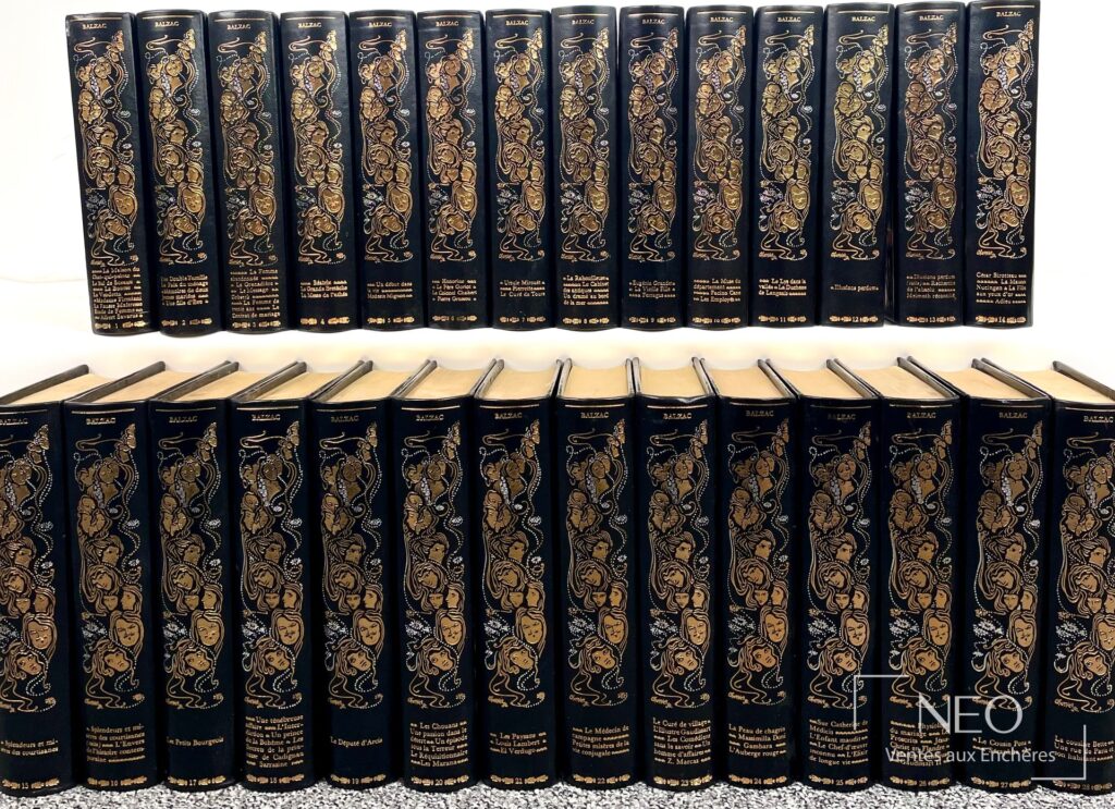 Ensemble de 28 volumes de Balzac aux dos noirs ornés de dorures et de visages stylisés