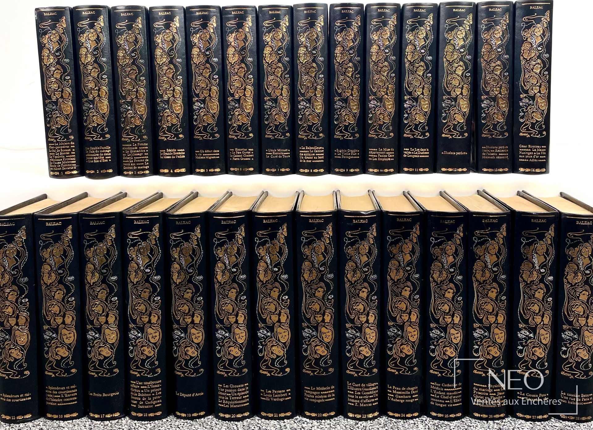 Ensemble de 28 volumes de Balzac aux dos noirs ornés de dorures et de visages stylisés