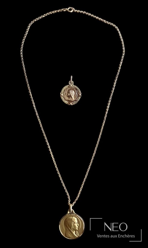 Chaîne en or avec deux médailles religieuses en pendentif sur fond noir