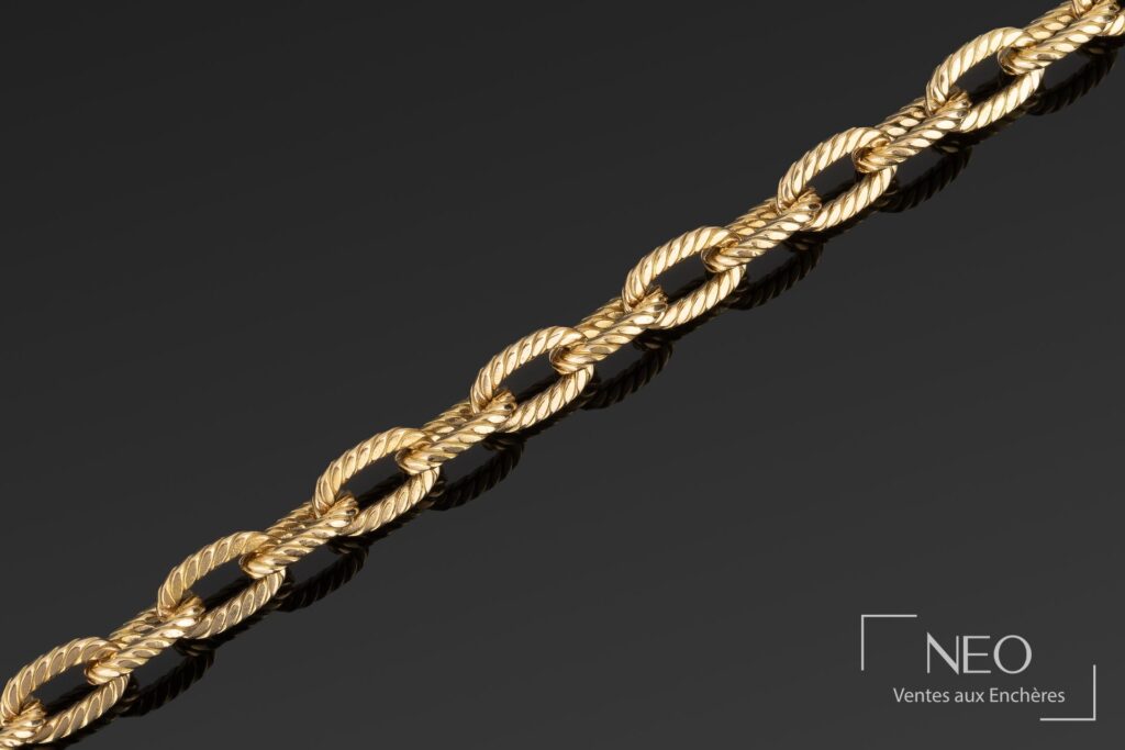 Gros plan sur la maille ovale torsadée d'un bracelet en or jaune Boucheron