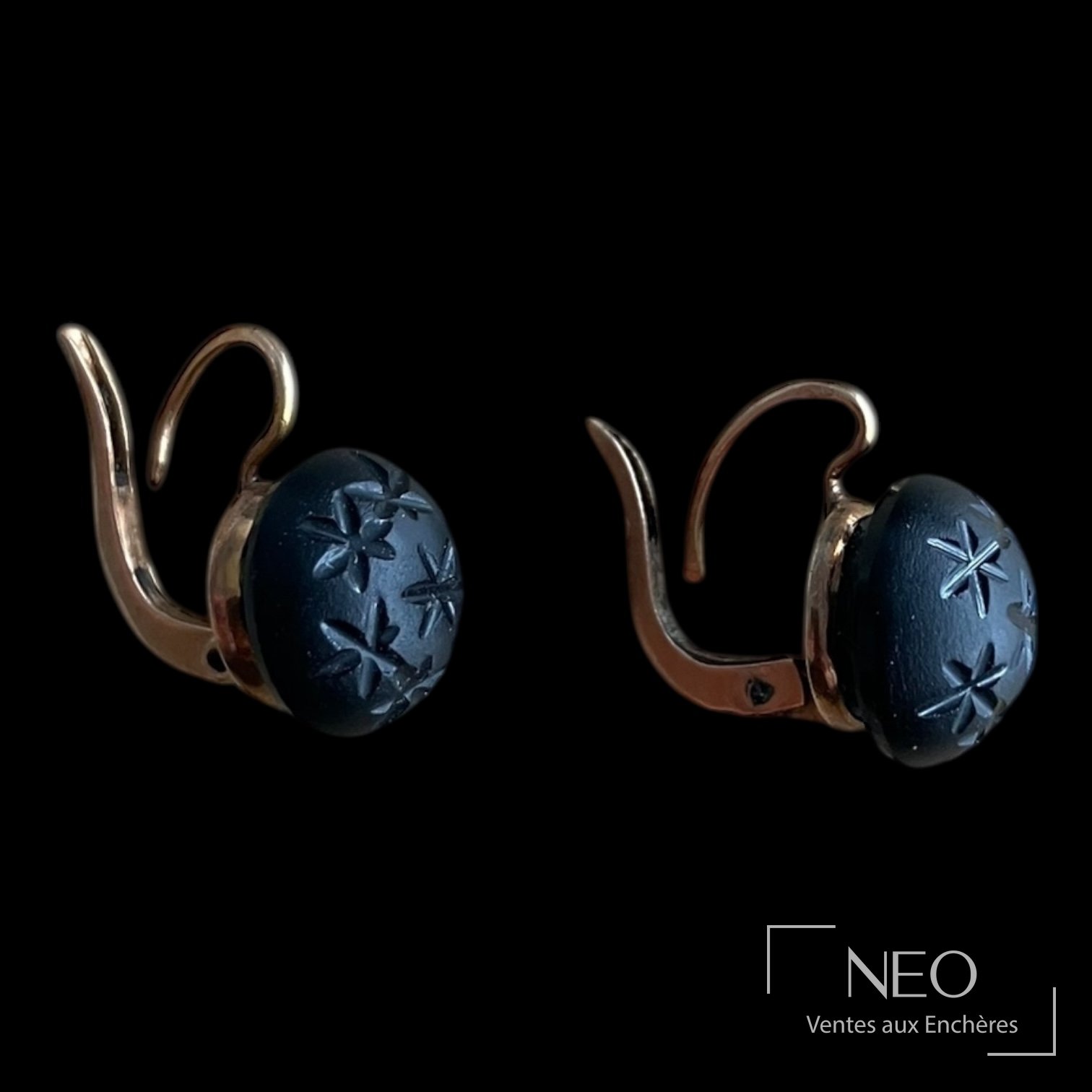 Paire de boucles d'oreille en or rose avec cabochons noirs gravés d'étoiles stylisées