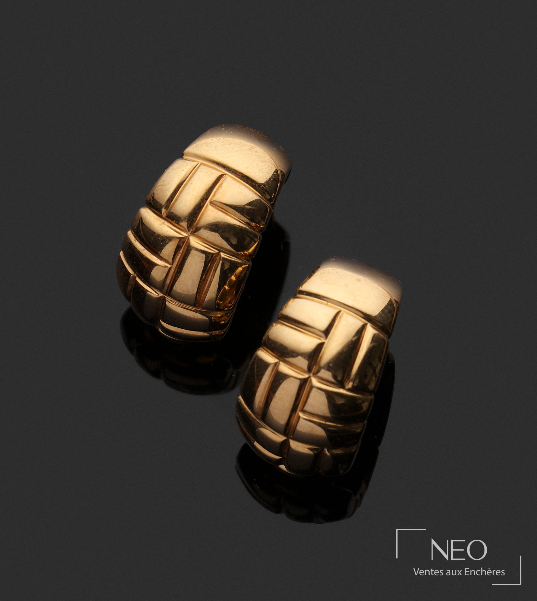 Paire de boucles d’oreilles en or jaune à décor géométrique strié sur fond noir
