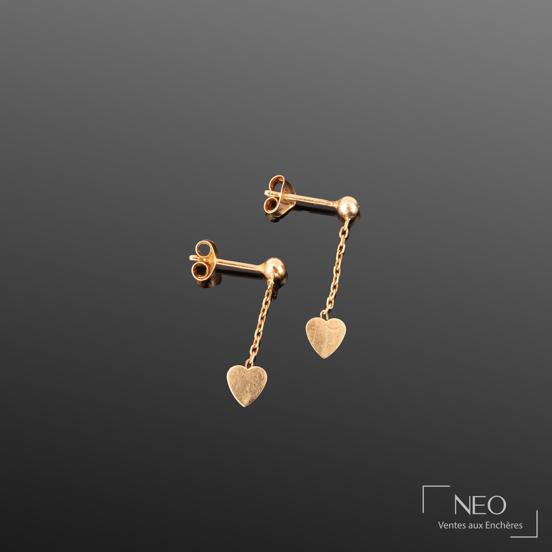 Paire de boucles d’oreilles en or jaune avec petits cœurs suspendus par une chaîne