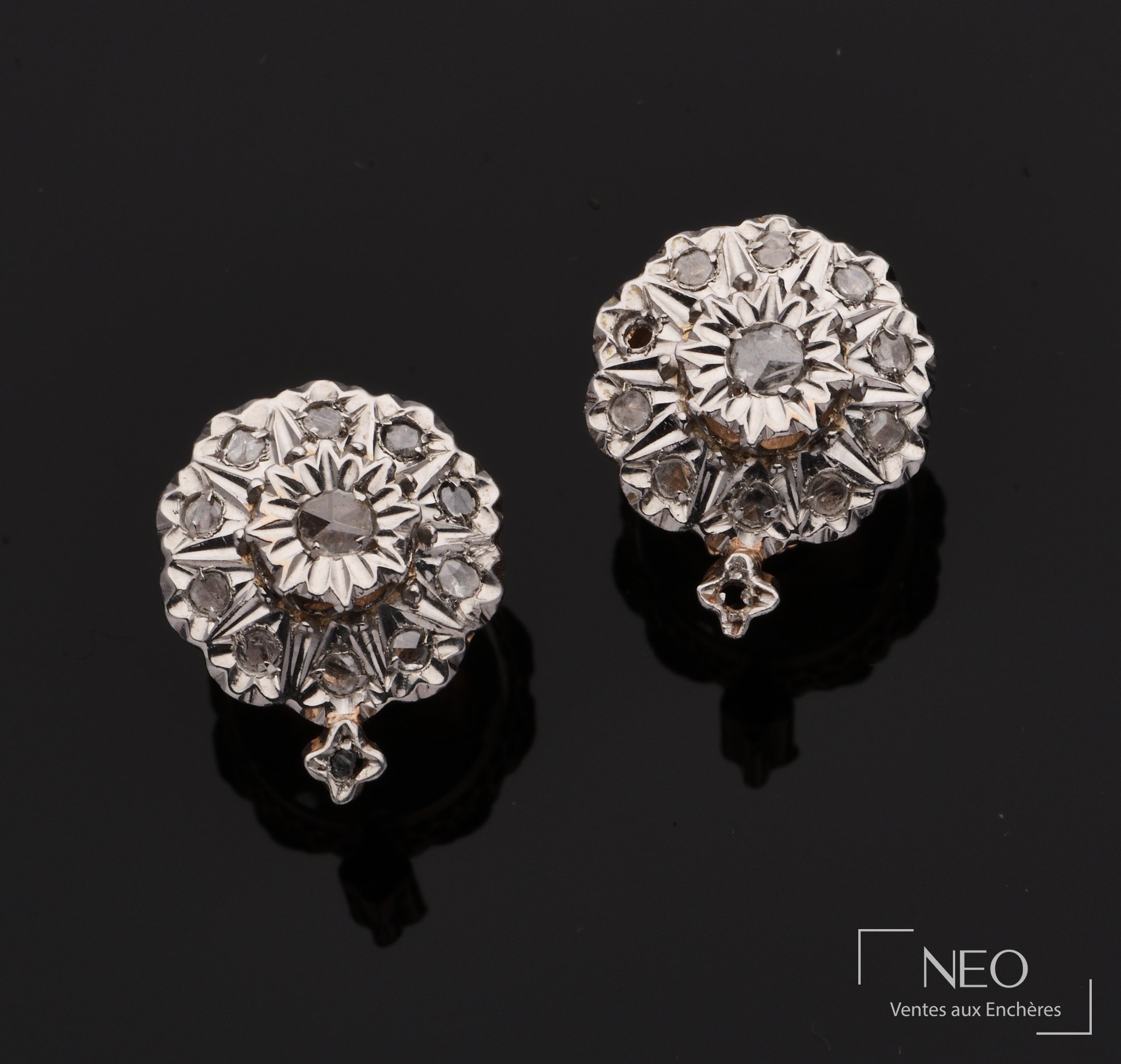 Paire de boucles d’oreilles rondes en ors jaune et gris serties de diamants sur fond noir