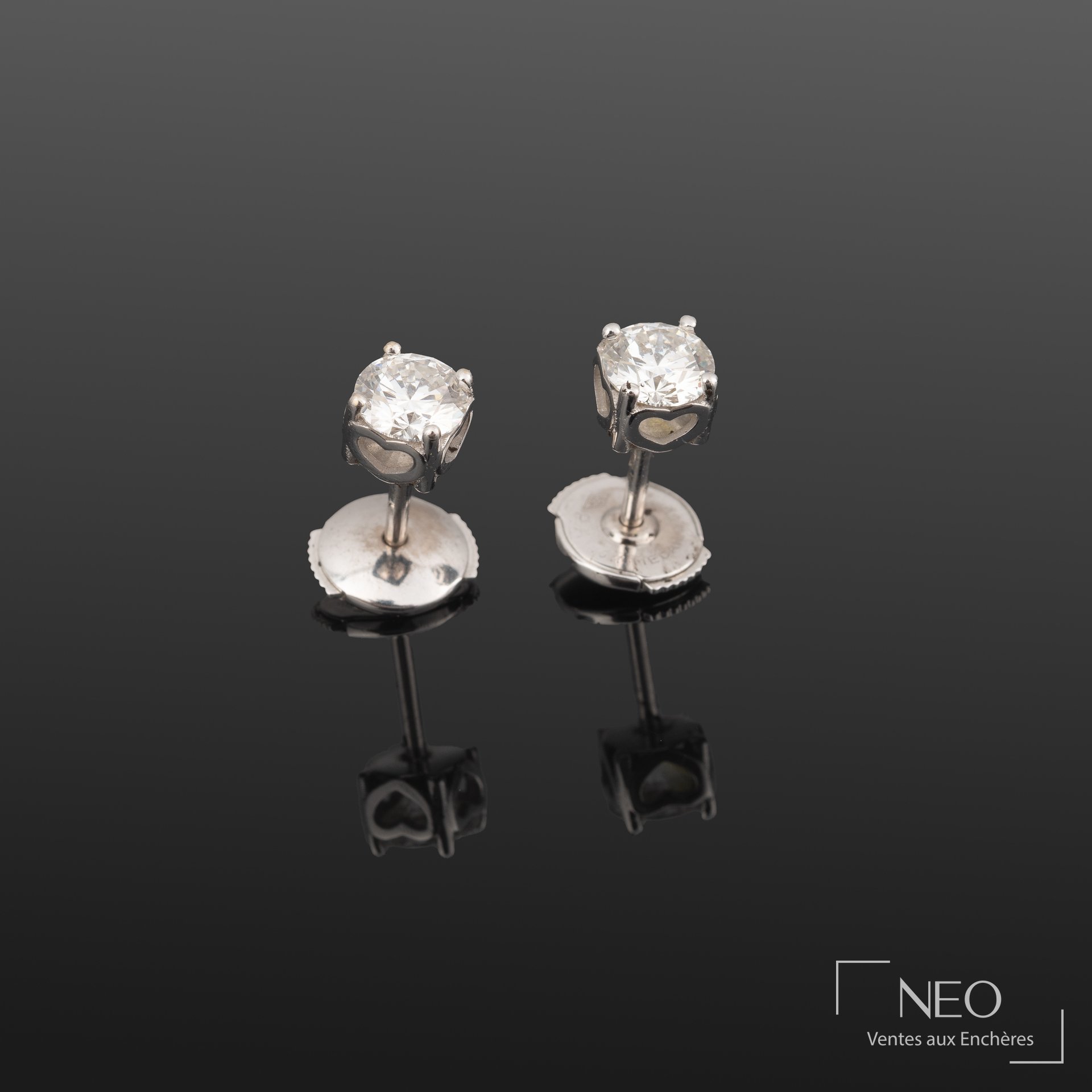 Paire de boutons d’oreilles en or gris sertis de diamants sur fond gris