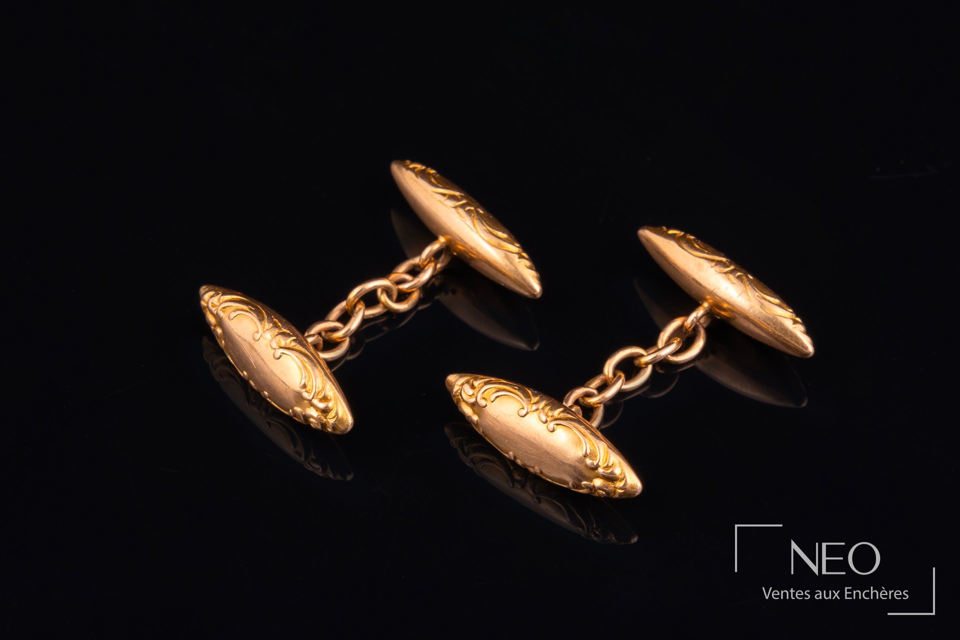 Paire de boutons de manchette en or jaune à décor gravé sur fond noir