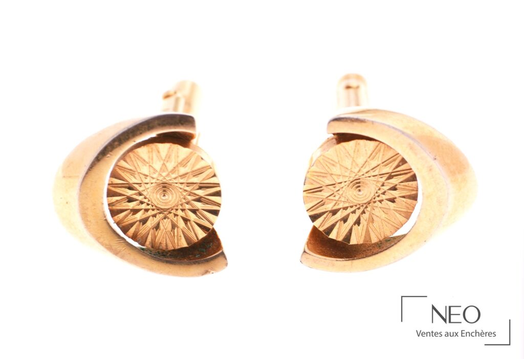 Paire de boutons de manchettes en métal doré à décor de fleurs stylisées
