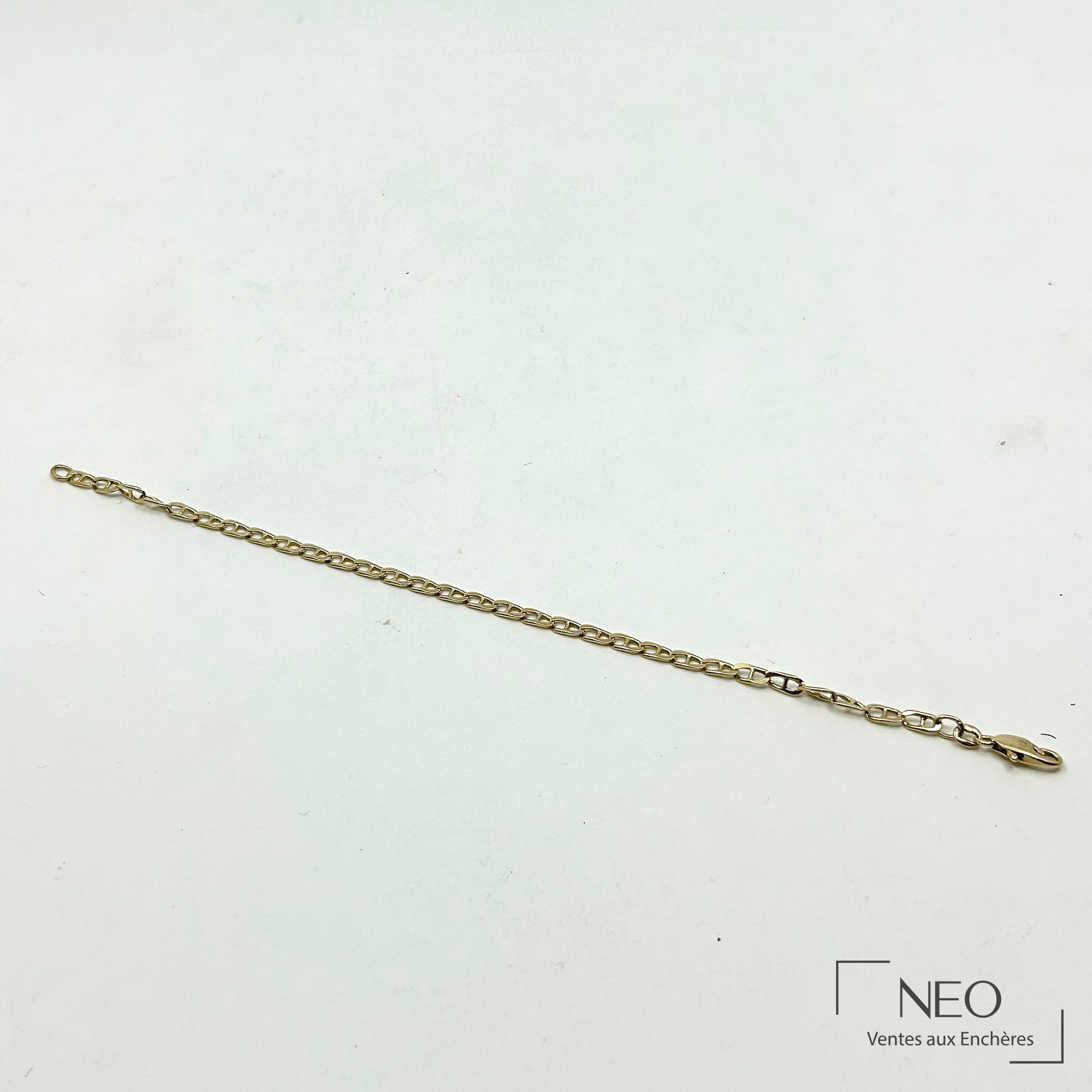 Bracelet à maille marine en or jaune posé sur fond clair