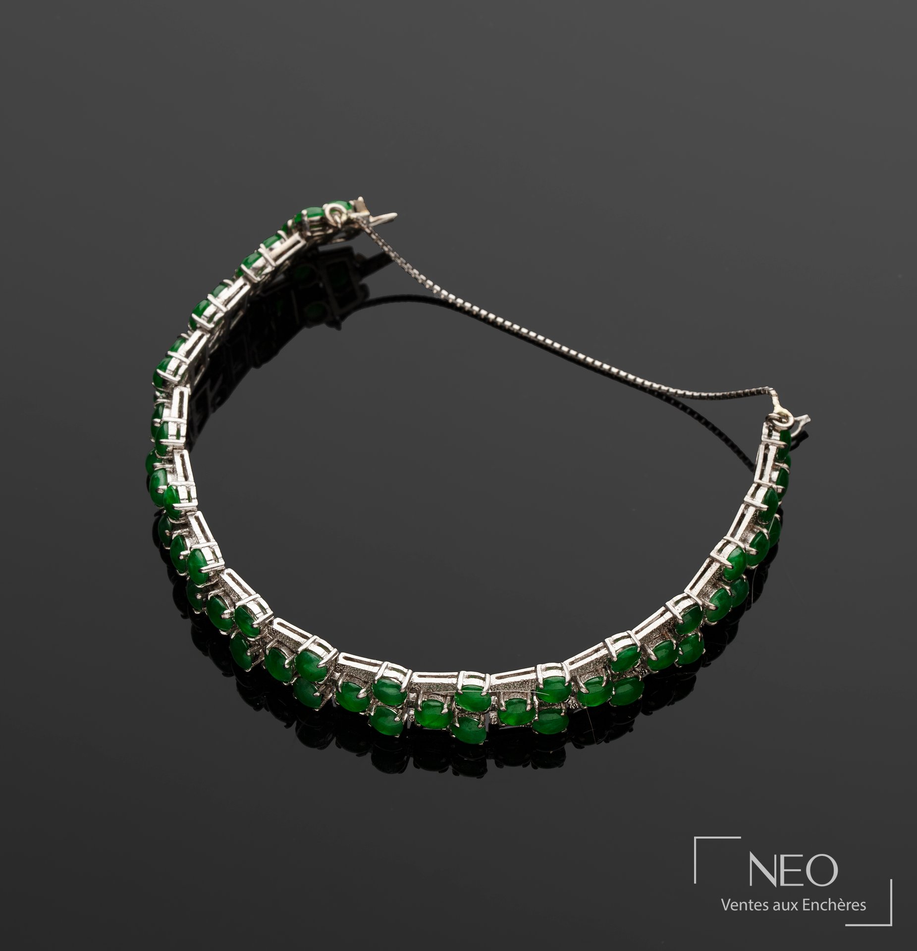 Bracelet souple en argent serti de cabochons verts sur fond noir