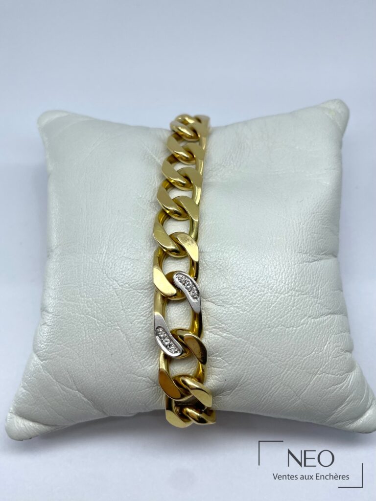 Bracelet gourmette en or jaune avec deux maillons sertis de diamants sur coussin blanc