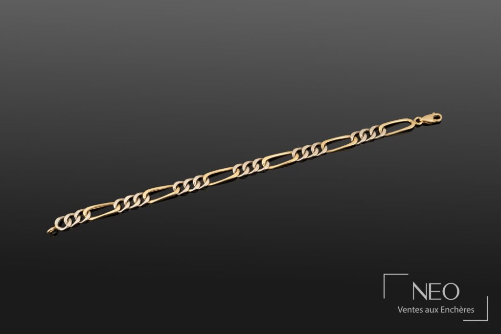 Bracelet gourmette en or jaune et gris présenté de face sur fond sombre