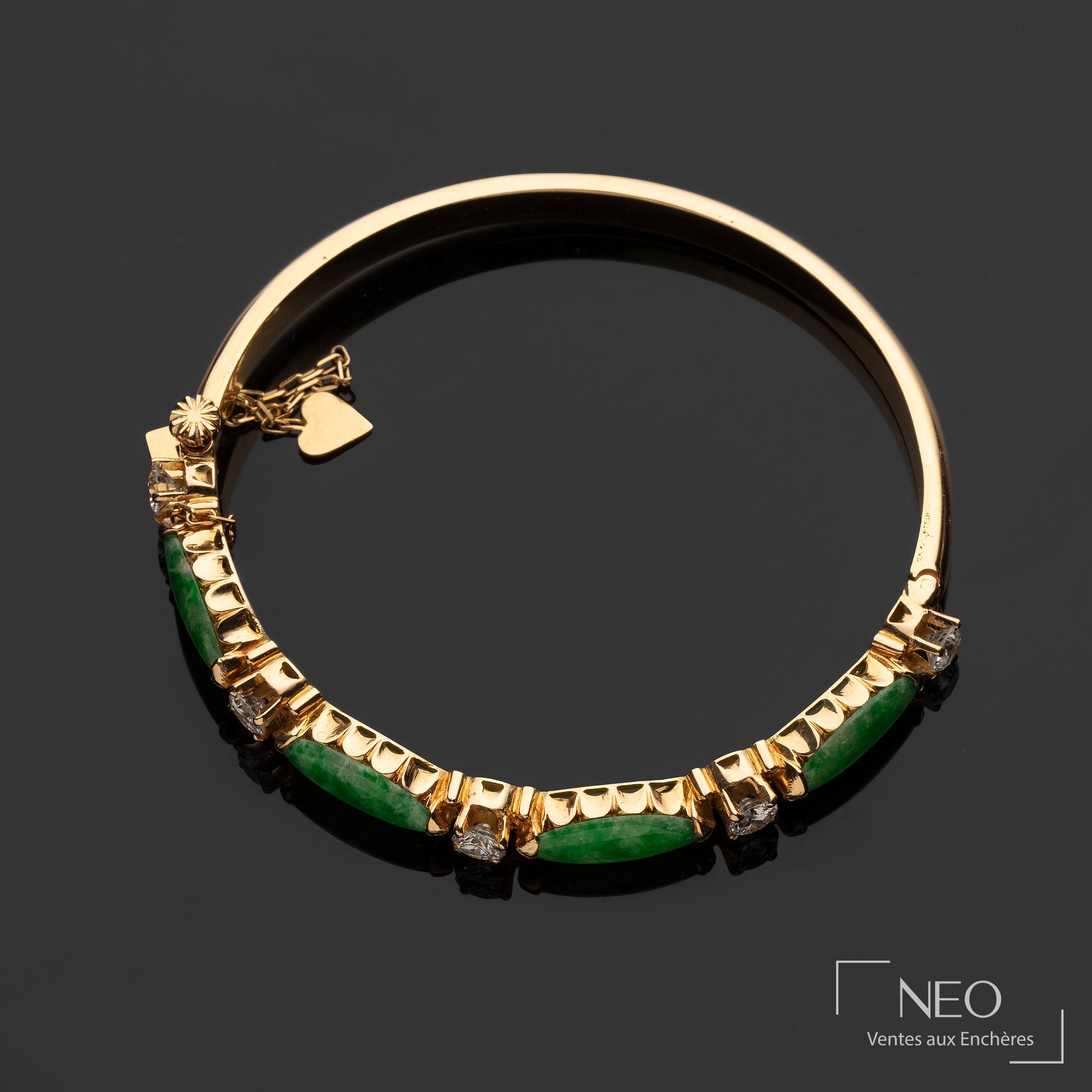 Bracelet jonc en or jaune orné de jade et de diamants sur fond noir