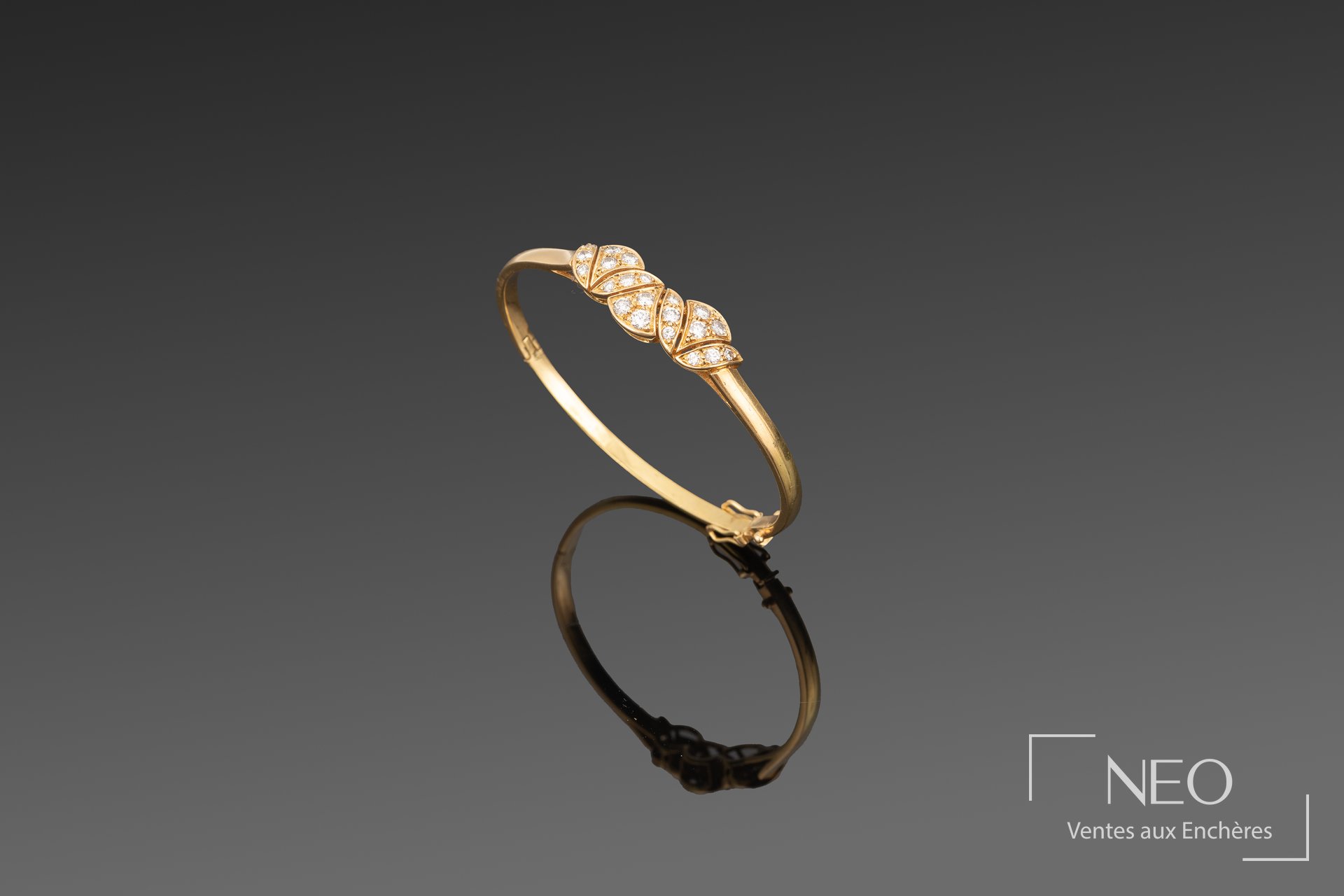 Bracelet jonc en or jaune orné de trois fleurs de lotus pavées de diamants