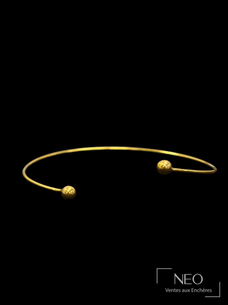 Bracelet jonc ouvrant en or jaune terminé par deux boules