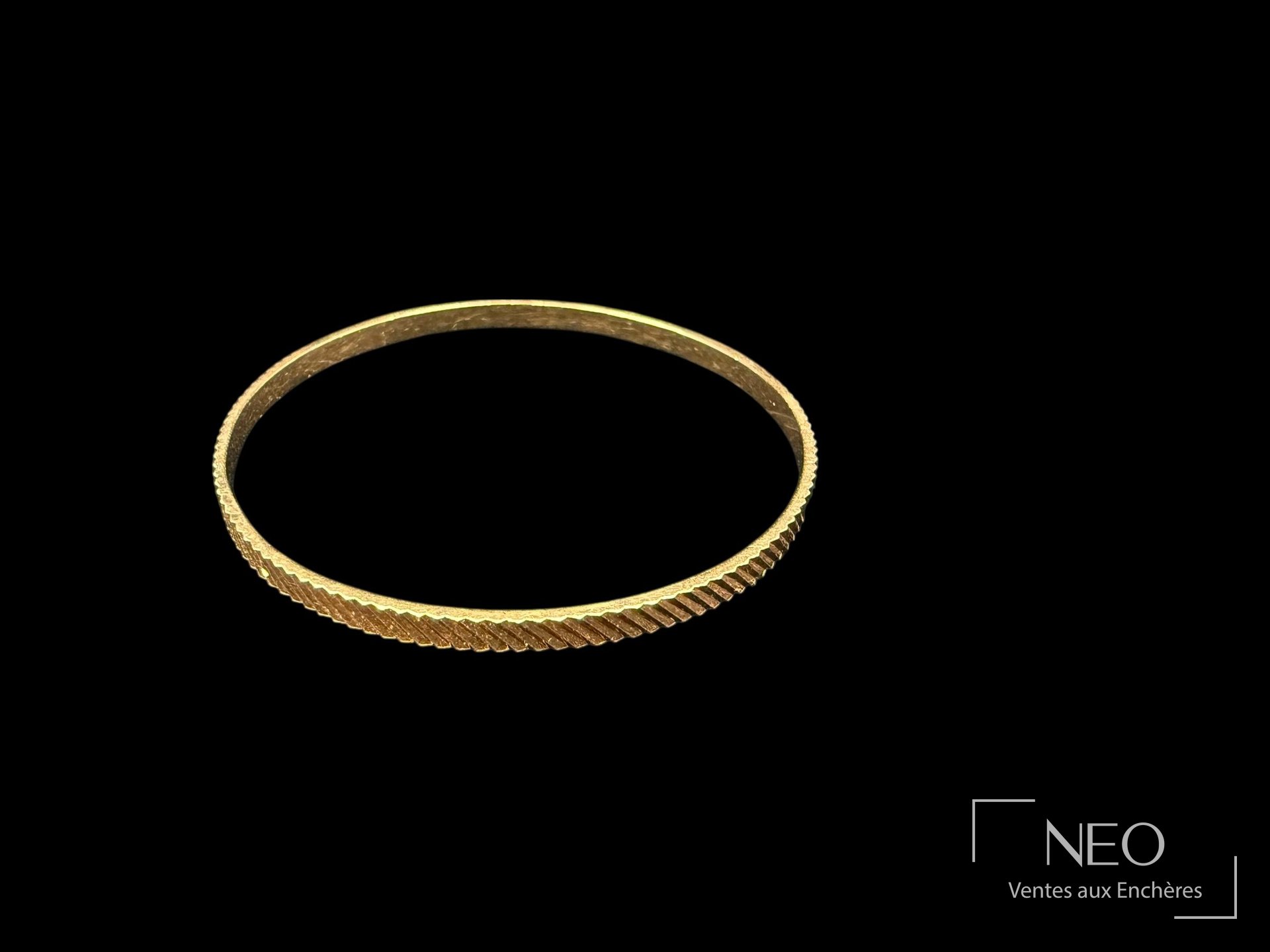 Bracelet jonc en or rose à motif strié sur fond noir