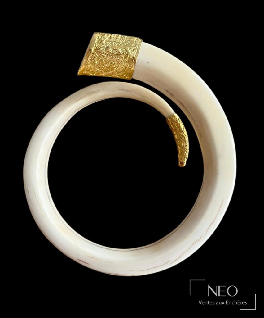 Bracelet jonc ouvrant en résine beige avec extrémités en or jaune décorées d'une tête de dragon