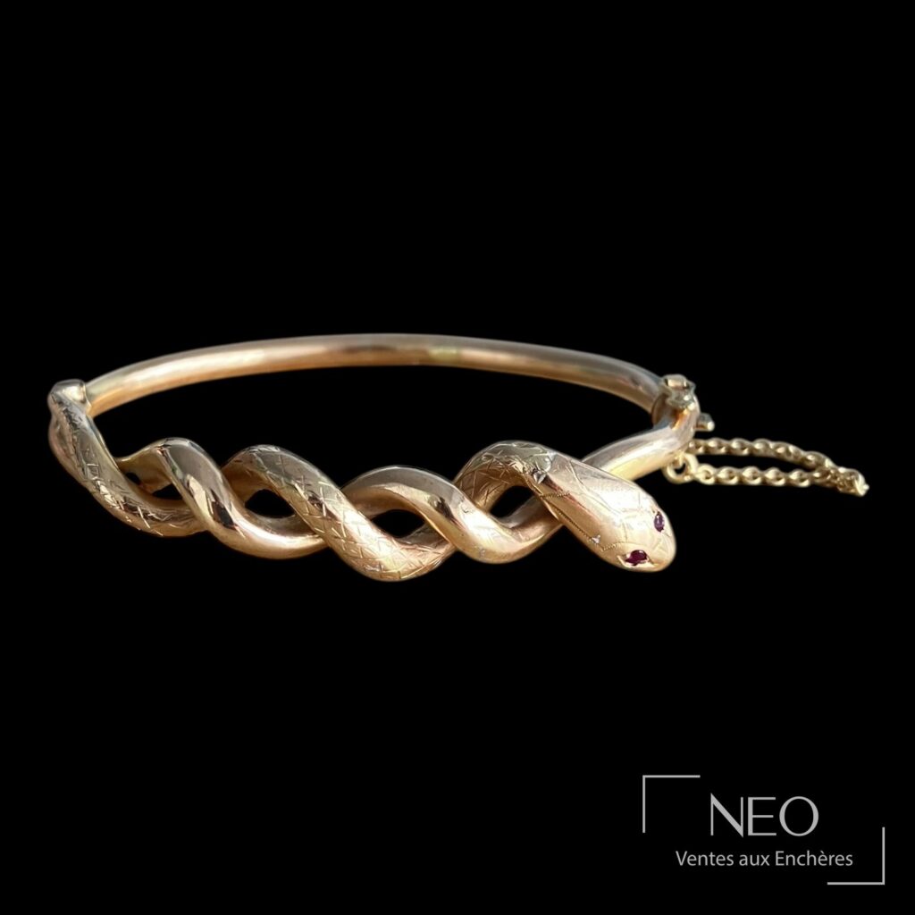 Bracelet jonc ouvrant en or rose avec décor de serpent et yeux sertis de rubis