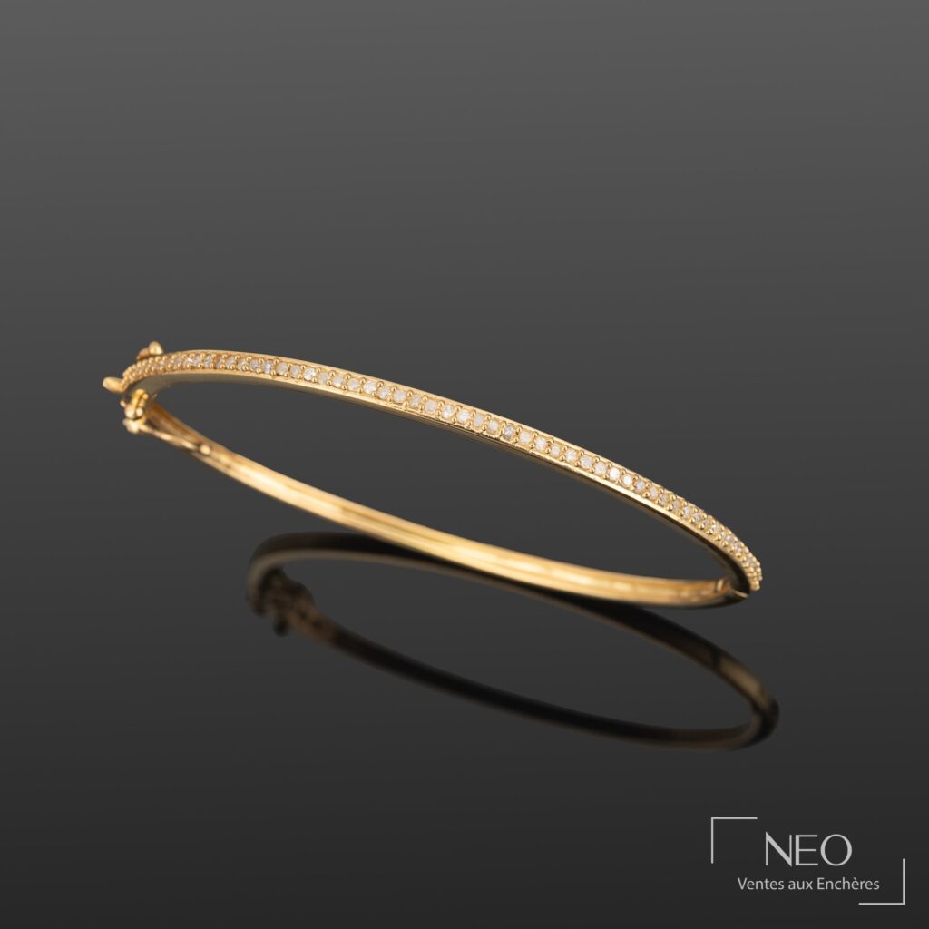 Bracelet jonc rigide en vermeil serti de diamants sur fond sombre