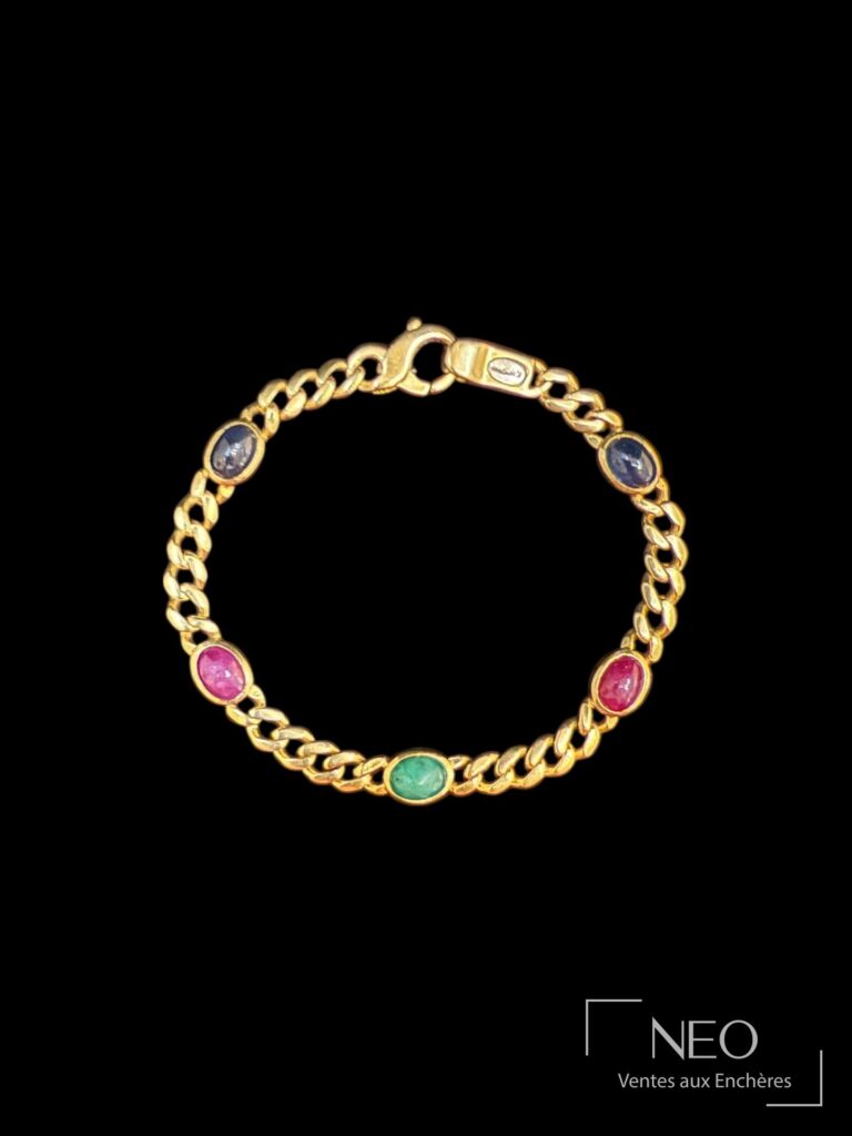 Bracelet en or jaune orné de cabochons de pierres de couleurs sur fond noir