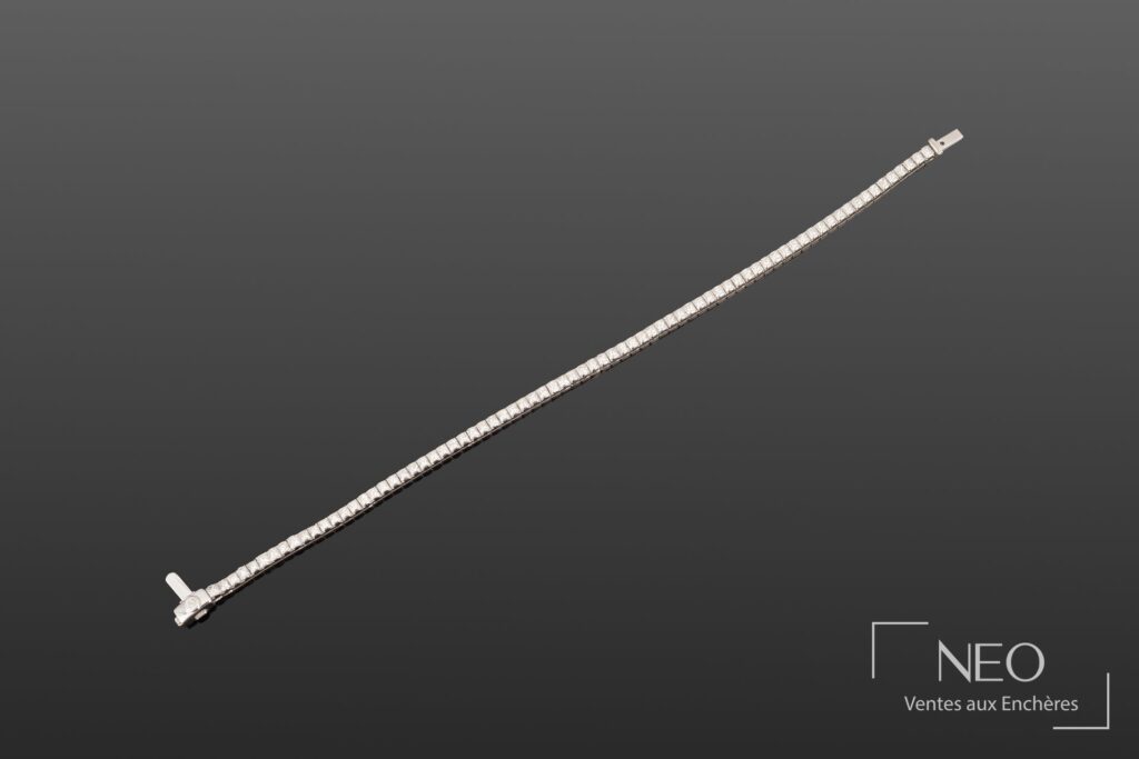 Bracelet ligne en or gris serti de diamants blancs sur fond neutre