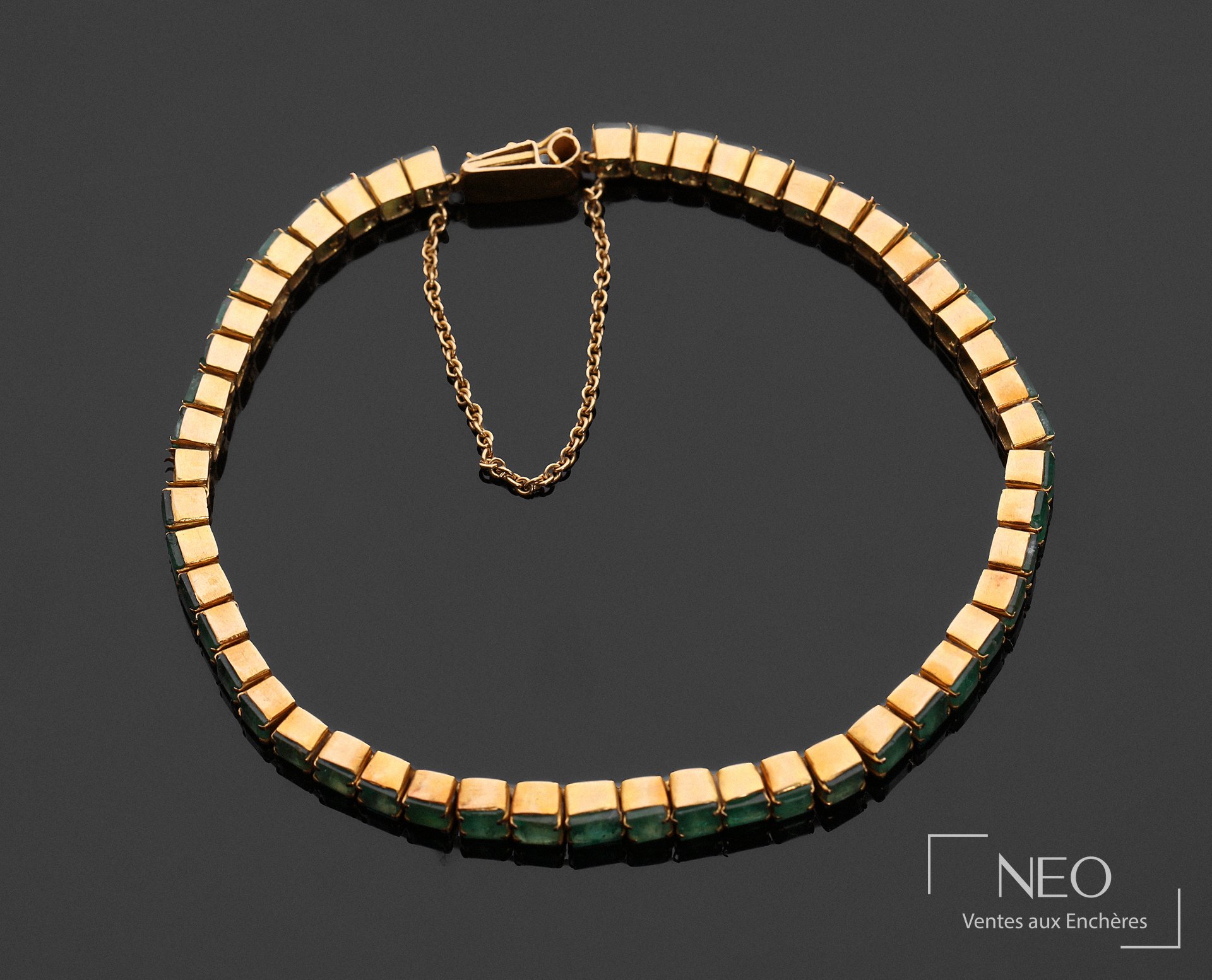 Bracelet ligne en or jaune 18 carats orné de pierres vertes